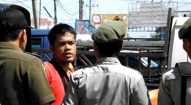 Pedagang melawan saat dagangannya disita oleh petugas.